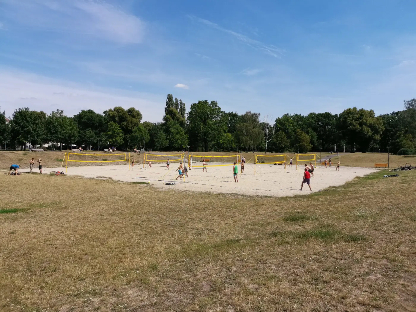 Beachvolleyball im Park Friedrichshain: Insgesamt passen 6 Beachvolleyballfelder in die Sandbox. Drum herum sitzen beim guten Wetter viele Zuschauer. Plätze im Schatten gibt es unter den Bäumen.